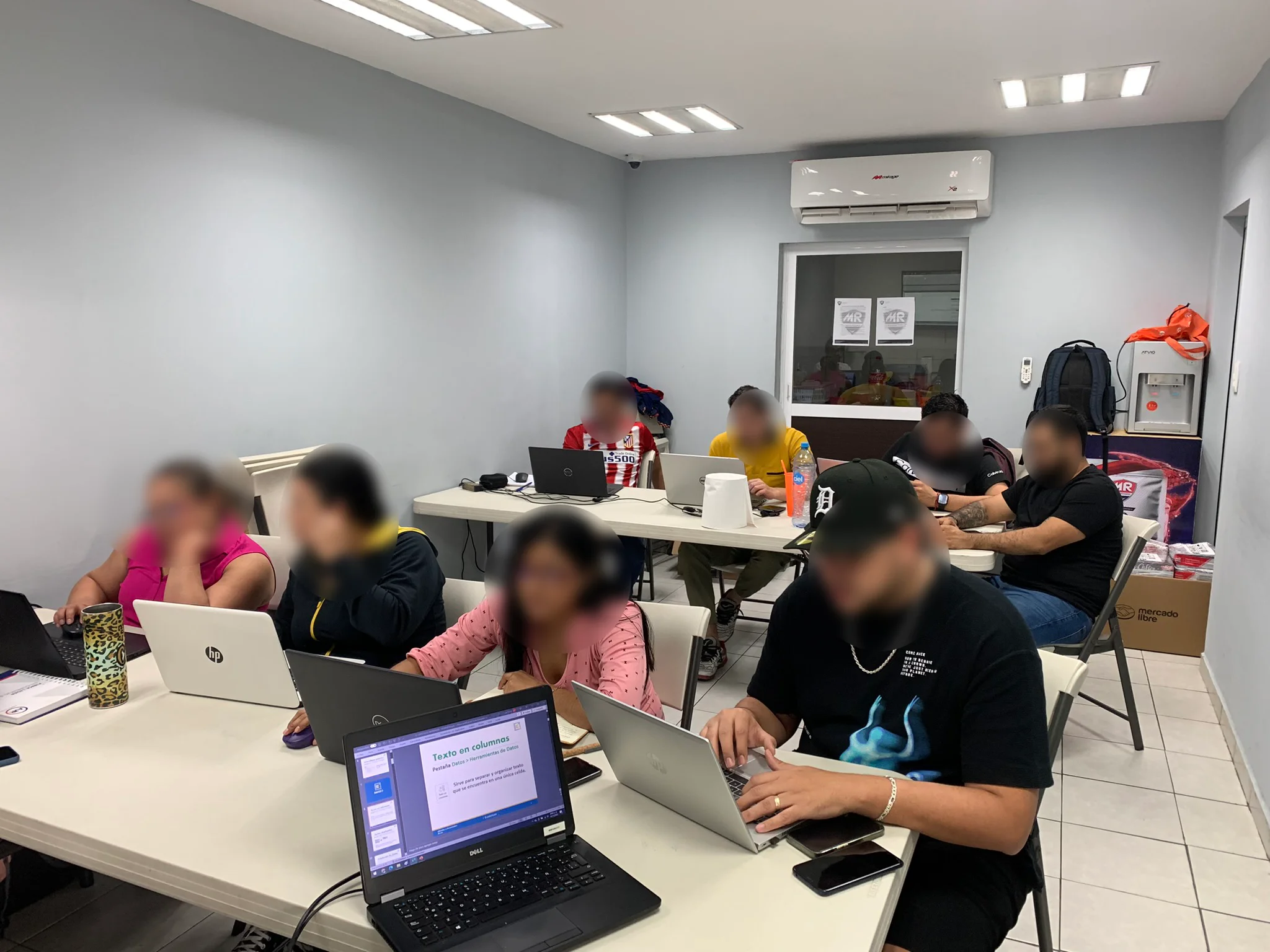 Grupo de participantes trabajando con computadoras durante una capacitación